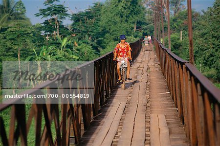 Woman Riding Bicycle on Bridge, Luang Prabang, Laos