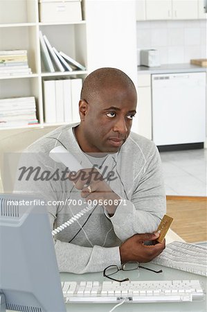 Man at Desk with Credit Card and Telephone