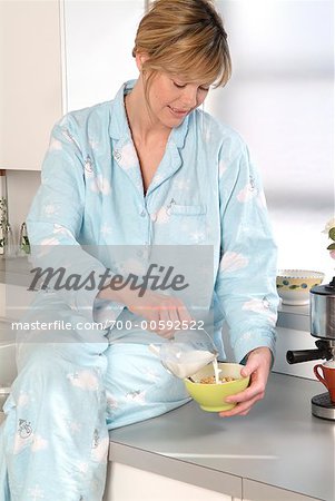 Woman Pouring Milk on Cereal