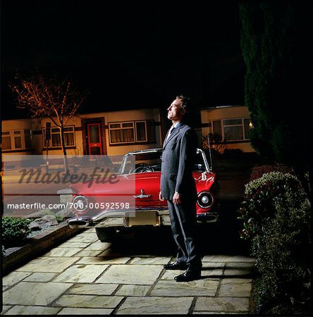 Man Standing in Driveway at Night