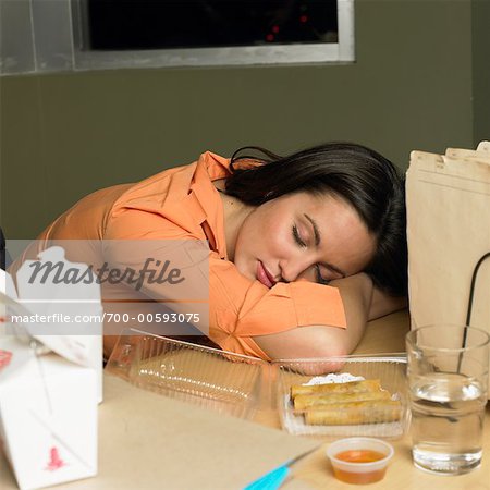 Woman Sleeping At Her Desk While Working Late Stock Photo