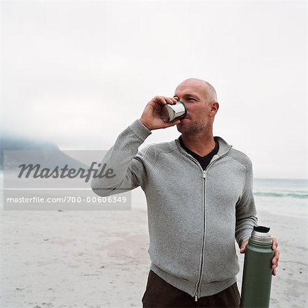 Man Drinking from Thermos on Beach - Stock Photo - Masterfile -  Rights-Managed, Artist: Masterfile, Code: 700-00606349