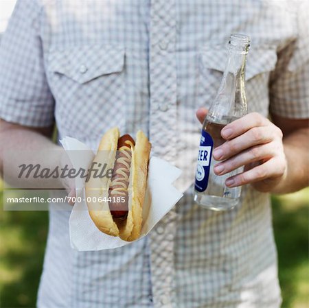 Man Holding Hot Dog and Bottle of Water