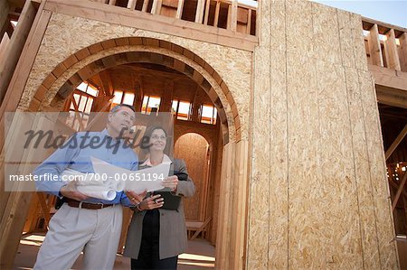 Man and Woman on Construction Site with Blueprints