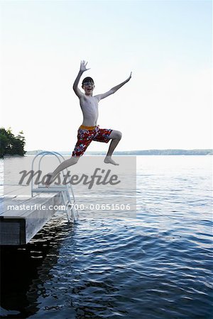 Boy Jumping off Dock into Lake