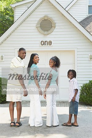 Family Standing In Front Of Garage