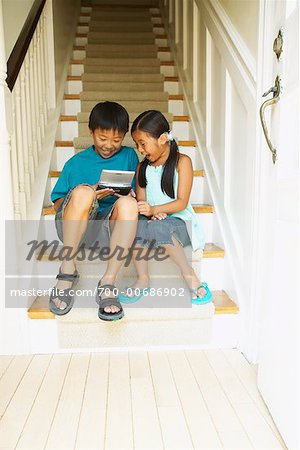 Boy and Girl with Handheld Video Game