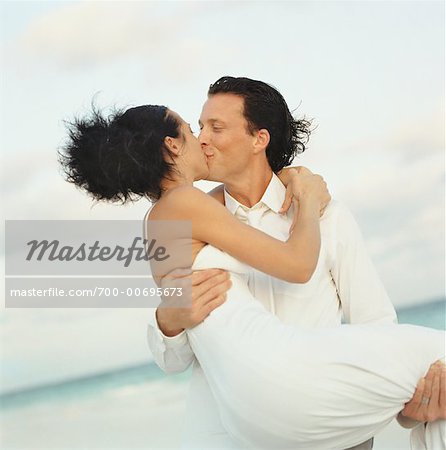 Bride and Groom Kissing on Beach