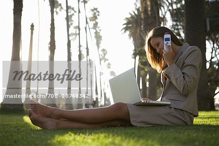 Businesswoman Sitting Outdoors With Laptop and Cell Phone