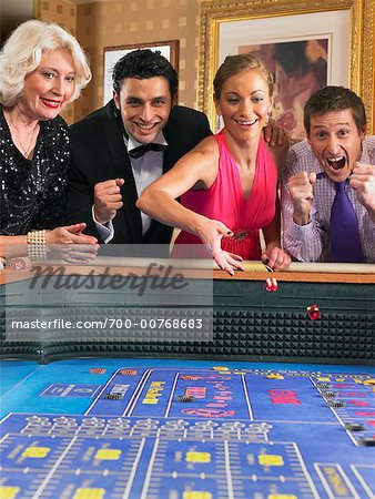 Happy Group Of Adults Gambling At Craps Table Stock Photo