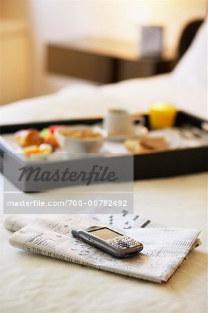 Breakfast Tray, PDA and Newspaper on Hotel Bed