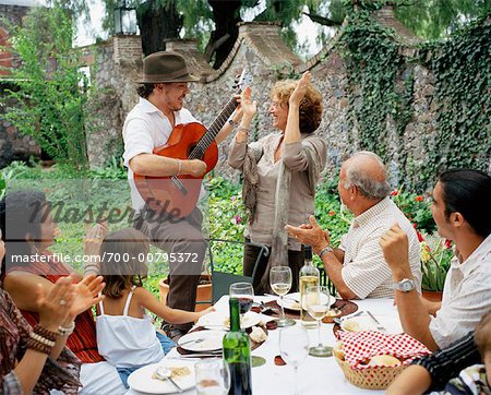Man Playing Guitar at Dinner Party