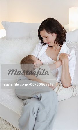 Woman Breastfeeding Baby on Sofa