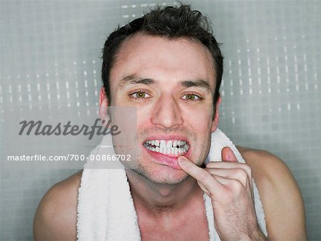 Man Checking Teeth in Mirror