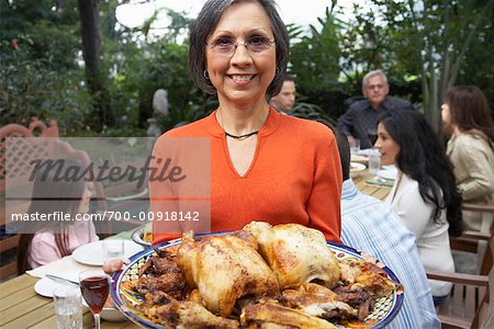 Woman Holding Platter Of Food At Dinner Outdoors