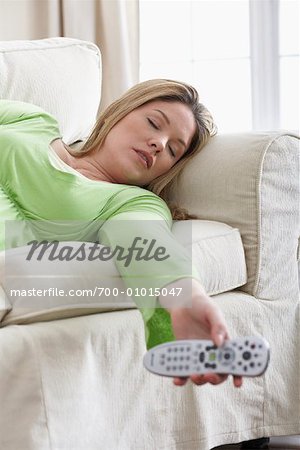 Woman Asleep with Remote Control on Sofa