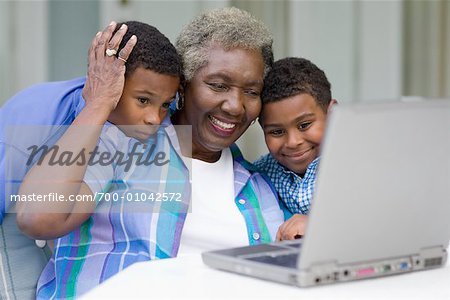 Grandmother and Grandsons Using Laptop Computer