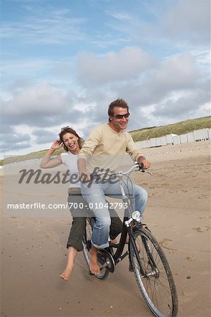 Couple Riding Bicycle on Beach