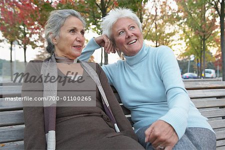 Women Sitting on Park Bench Talking