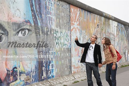 Couple Walking Along the Berlin Wall, Berlin, Germany