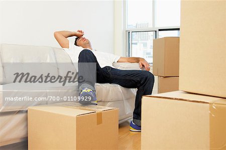 Man Resting on Couch After Moving Into New Home