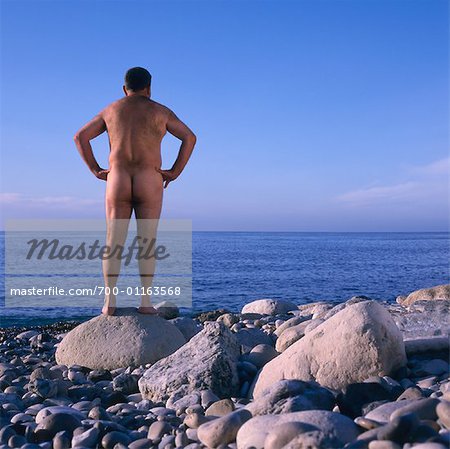Naked Man Standing on Beach