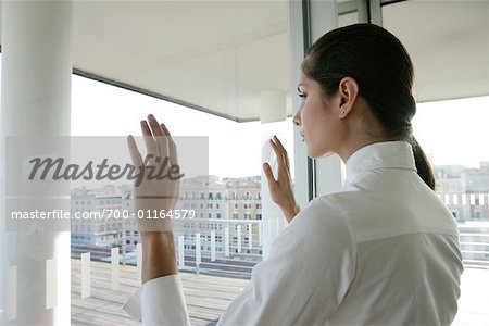Businesswoman Pressing Hands Against Window