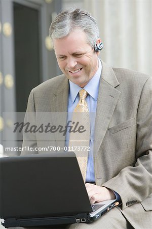 Businessman Using Laptop and Cell Phone