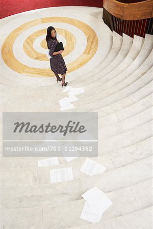 Businesswoman Dropping Papers while Descending Stairs