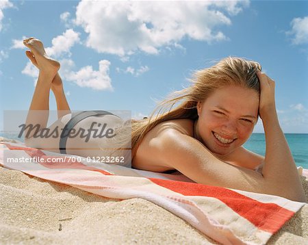 Young Woman Wearing Bikini Bottoms Lying On Towel Sunbathing Stock Photo,  Picture and Royalty Free Image. Image 62344604.