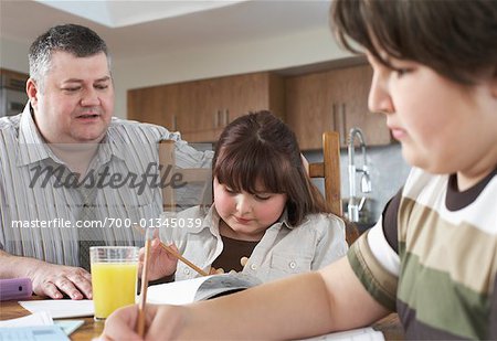 Father Watching Children do Homework