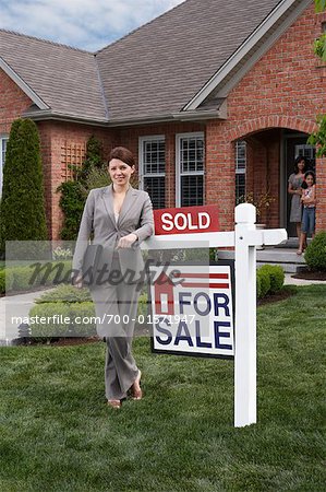 Real Estate Agent by Sold Sign