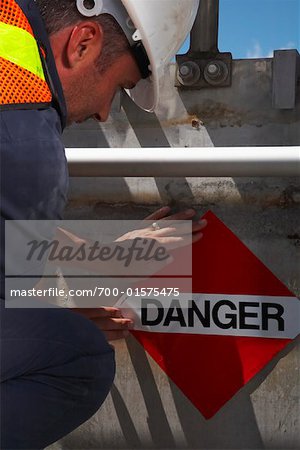 Man Putting up Danger Sign