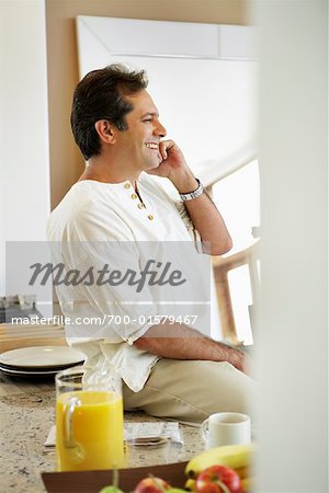 Man Using Phone in Kitchen