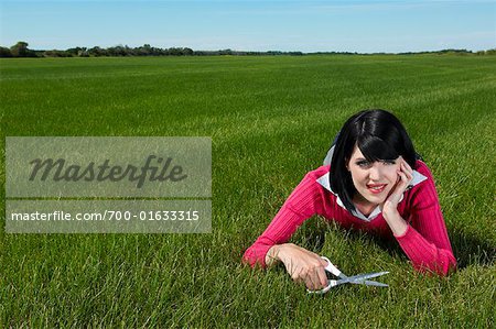 Woman Cutting Grass With Scissors