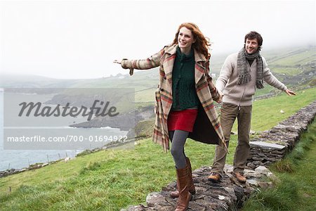 Couple Walking Along Stone Wall, Ireland Couple Walking Along Stone Wall, Ireland
