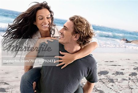 Free Photo  Man giving piggyback ride to woman on the beach