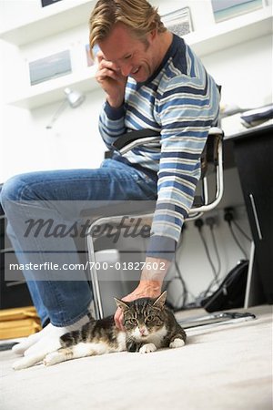 Man Talking on Cell Phone and Petting Cat