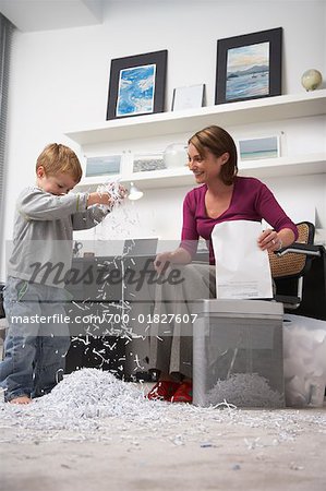 Woman and Boy Playing with Shredded Paper in Home Office