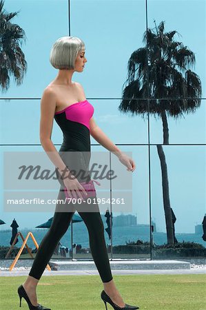 Futuristic Woman Walking in Front of Glass Building