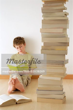 Boy Reading with Pile of Books