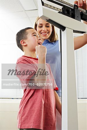 Physiotherapist Weighing Boy on Scale