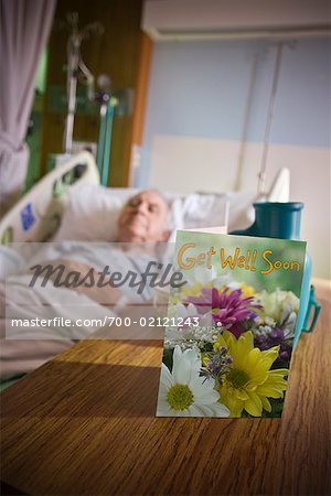 Elderly Man in Hospital with Get Well Soon Card on Table