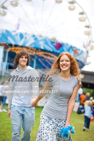 Teenage Girl and Boy Holding Hands at a Carnival