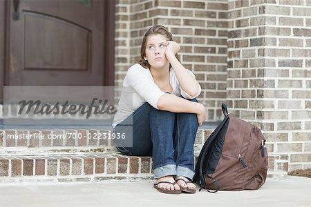 Teenaged Girl Sitting on Steps, Looking Upset