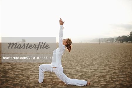 Woman Practicing Yoga on Beach, Santa Monica, California, USA