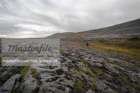 Woman Hiking Across Field, Slieve Rua, Burren National Park, County Clare, Ireland