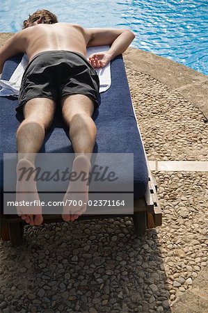 Man Relaxing on Lounge Chair by Swimming Pool, Mallorca, Baleares, Spain