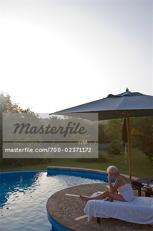 Woman Relaxing by Swimming Pool at Dusk, Mallorca, Baleares, Spain