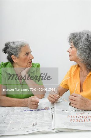 Two Women Talking about News in Paper